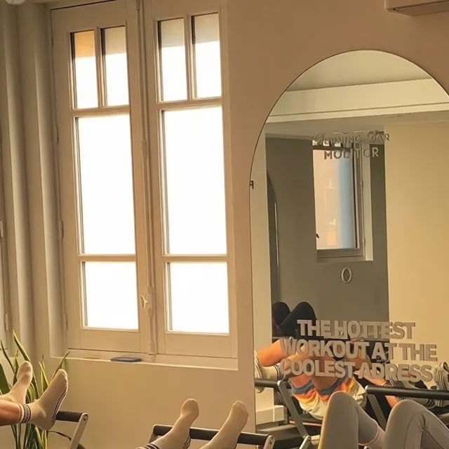 Grandes fenêtres et miroir en arcade pendant un cours de Reformer